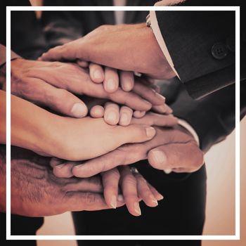 Business team stacking hands together in office