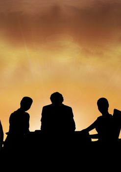 Digital composite of Business people at a meeting silhouette against sunset or sunrise
