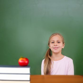 Red apple on pile of books against cute pupil