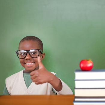 Cute pupil showing thumbs up against red apple on pile of books