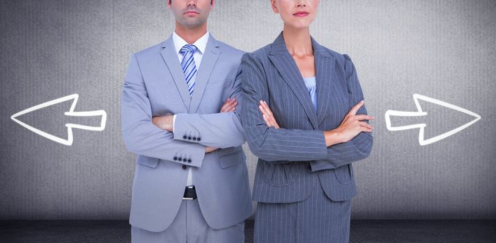 Business people with arms crossed looking at camera against grey room