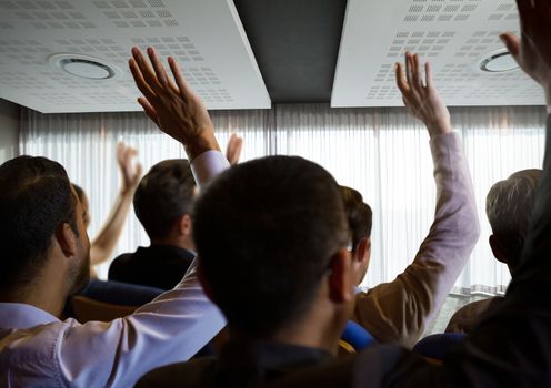 Digital composite of Business people with raised hands up at conference by windows
