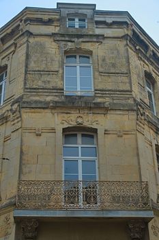 Old traditional French stone corner building with wooden windows