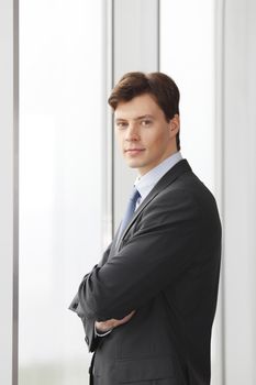 Portrait of young handsome business man in office looking at camera