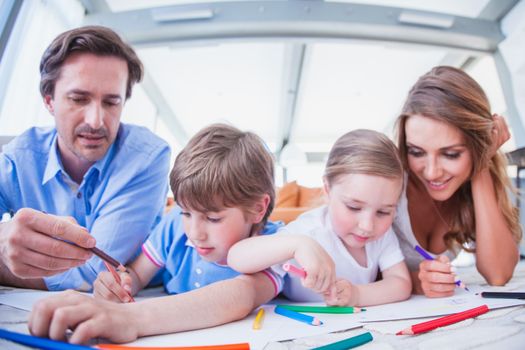 Family drawing lying on the floor , children with their parents together