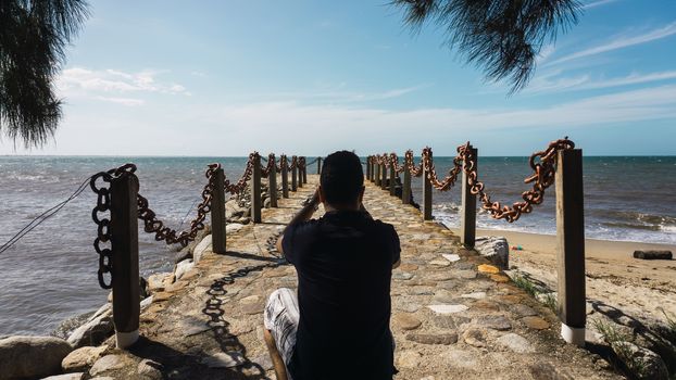 Photographer taking a photo on the pier with a pretty sea view