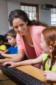 Cute pupils in computer class with teacher at the elementary school