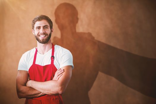 Portrait of smiling confident male owner with arms crossed against brown grocery bag texture