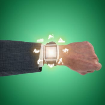 Cropped hand of businessman wearing smart watch against green vignette