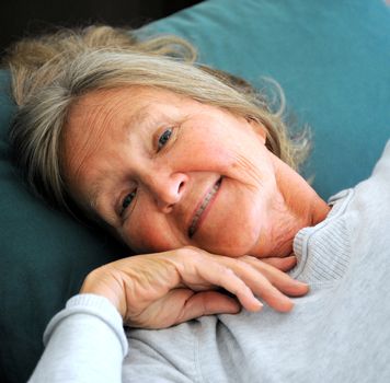 Mature female senior relaxing in bed.