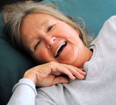 Mature female senior relaxing in bed.