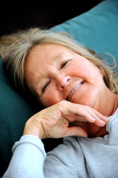 Mature female senior relaxing in bed.