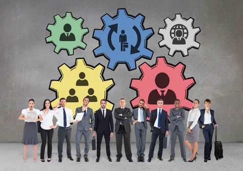 Digital composite of Business people standing against people in cogs graphics against grey background