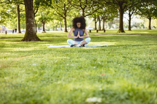 Woman performing yoga in the park on a sunny day