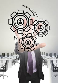 Digital composite of Business man interacting with people in cogs graphics against office background
