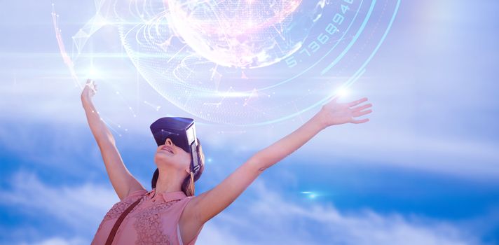 Woman with arms raised looking through virtual reality simulator against white background against global technology background in blue