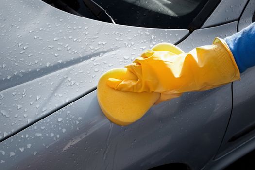 Cropped image of woman cleaning her car outdoors