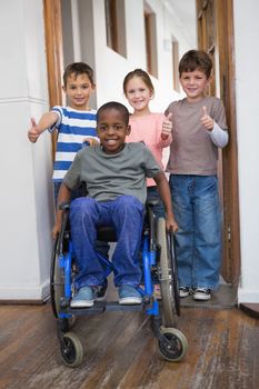 Disabled pupil with his friends in classroom at the elementary school