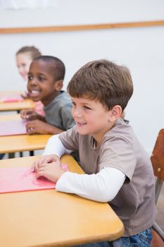 Cute pupils listening attentively in classroom at the elementary school