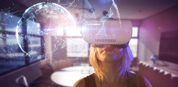 Woman looking through virtual reality simulator against global technology background in purple