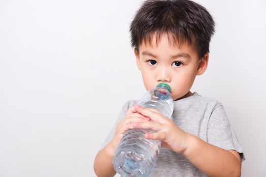 Closeup Asian face, Little children boy drinking water from Plastic bottle on white background with copy space, health medical care