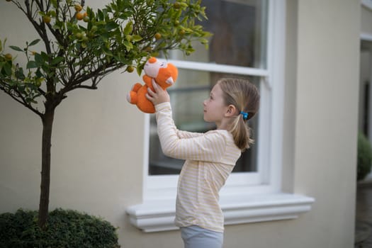 Young girl holding soft toy outdoors