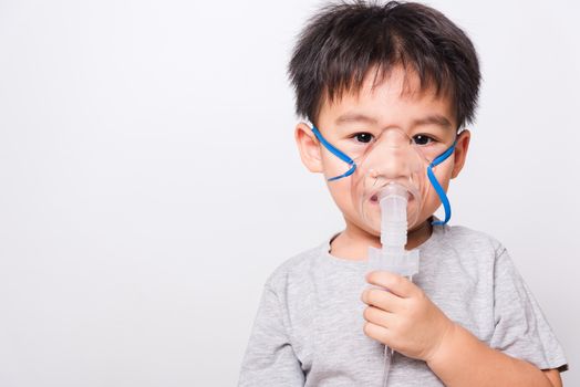 Closeup Asian face, Little children boy sick he using steam inhaler nebulizer mask inhalation oneself on white background, health medical care