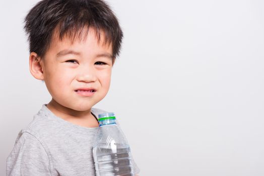 Closeup Asian face, Little children boy drinking water from Plastic bottle on white background with copy space, health medical care