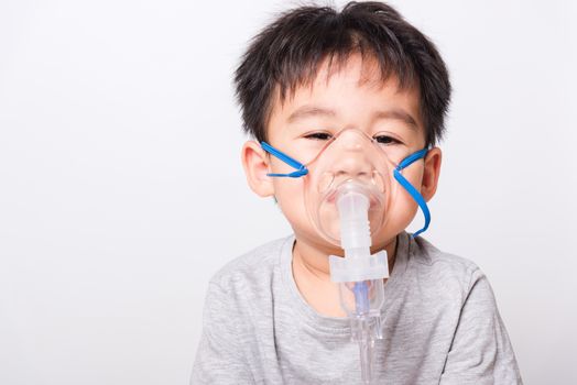 Closeup Asian face, Little children boy sick he using steam inhaler nebulizer mask inhalation oneself on white background, health medical care