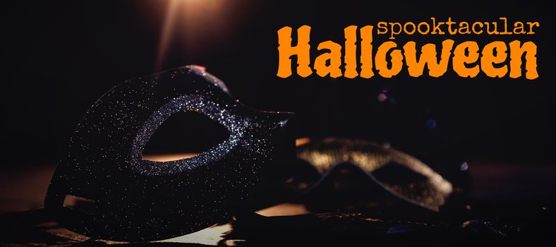 Graphic image of spooktacular Halloween text against masquerade masks on stage