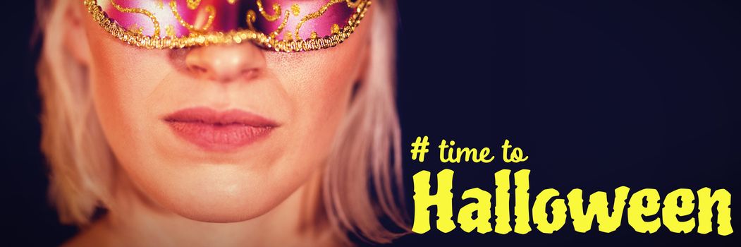 Digital image of time to Halloween text against close-up portrait of woman in masquerade mask