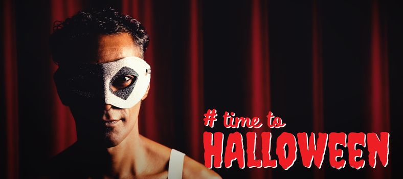 Digital composite image of time to Halloween text against portrait of man in masquerade mask