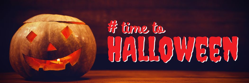 Digital composite image of time to Halloween text against illuminated jack o lantern on table during halloween