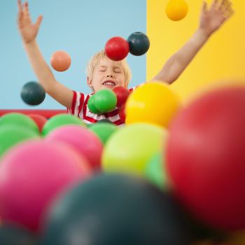 Happy boy playing in ball pool at a party