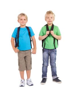 Cute little schoolboys smiling at camera on white background