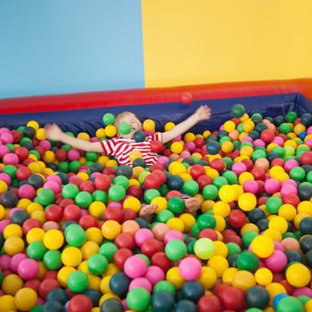 Happy boy playing in ball pool at a party