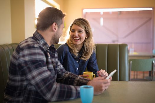 Romantic couple using digital tablet in restaurant