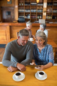 Senior couple interacting while using digital tablet in restaurant