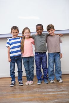 Classmates smiling at camera in classroom at the elementary school