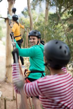 Friends enjoying zip line adventure in park on a sunny day