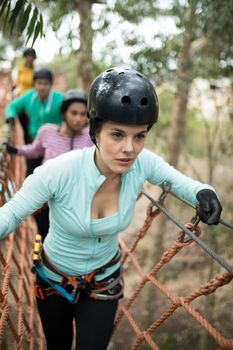 Beautiful woman walking on rope bridge