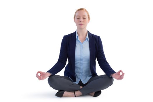 Businesswoman performing yoga against white background