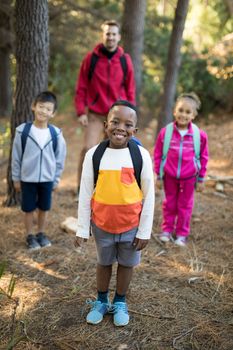 Happy kids and teacher standing in park