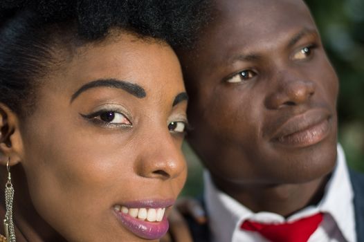 Close-up of faces of smiling young couple looking at the camera.