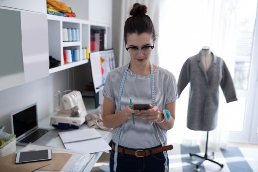 Fashion designer using mobile phone at home