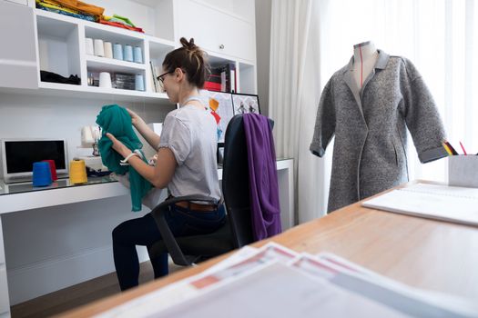 Fashion designer using sewing machine at home