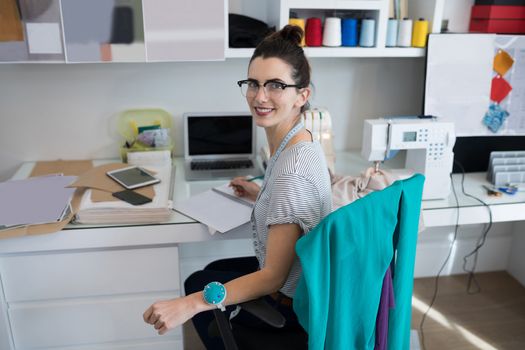 Smiling fashion designer working at desk