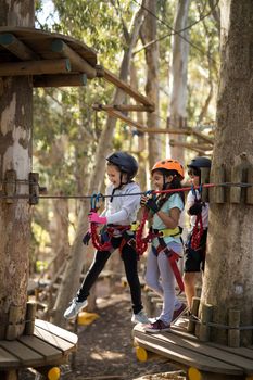 Kids crossing zip line on a sunny day