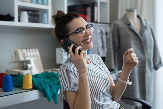 Fashion designer talking on mobile phone at home