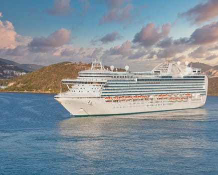 A huge white luxury cruise ship anchored in a bay off St. Thomas island in the Caribbean